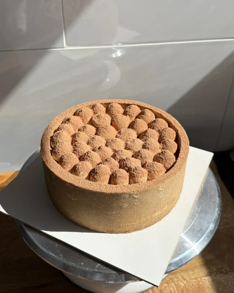 Cheesecake tiramisú terminado con cacao en polvo